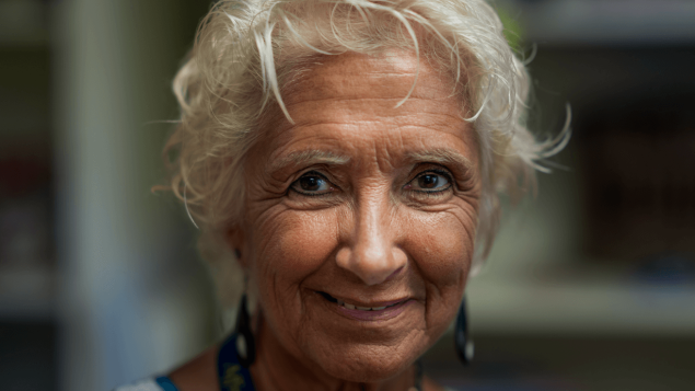 Das Portrait zeigt eine alte Frau mit weißen Haaren und dunklen Augen.