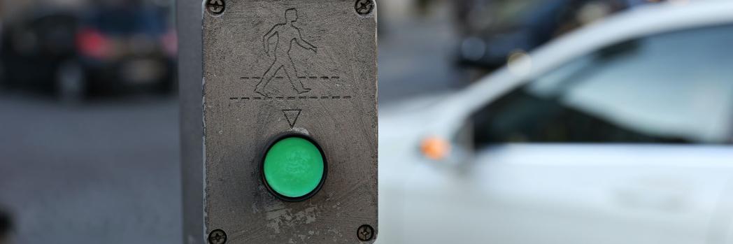 Tafel mit grünem runden Knopf und laufendem Mensch