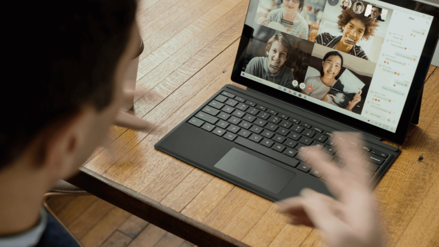 Ein Mann sitzt vor einem Laptop und führt dort ein digitales Meeting mit vier anderen Teilnehmern.