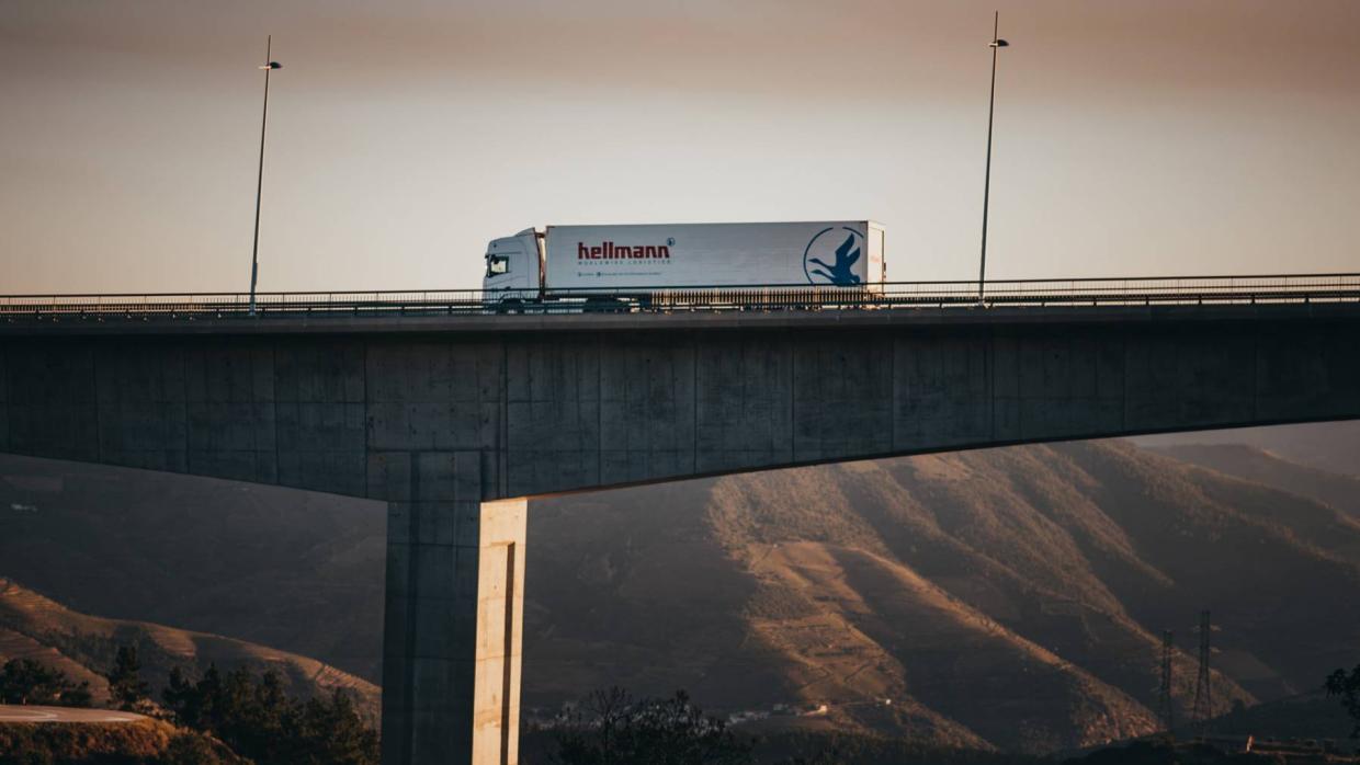 A truck from the Hellmann company crosses a large bridge.