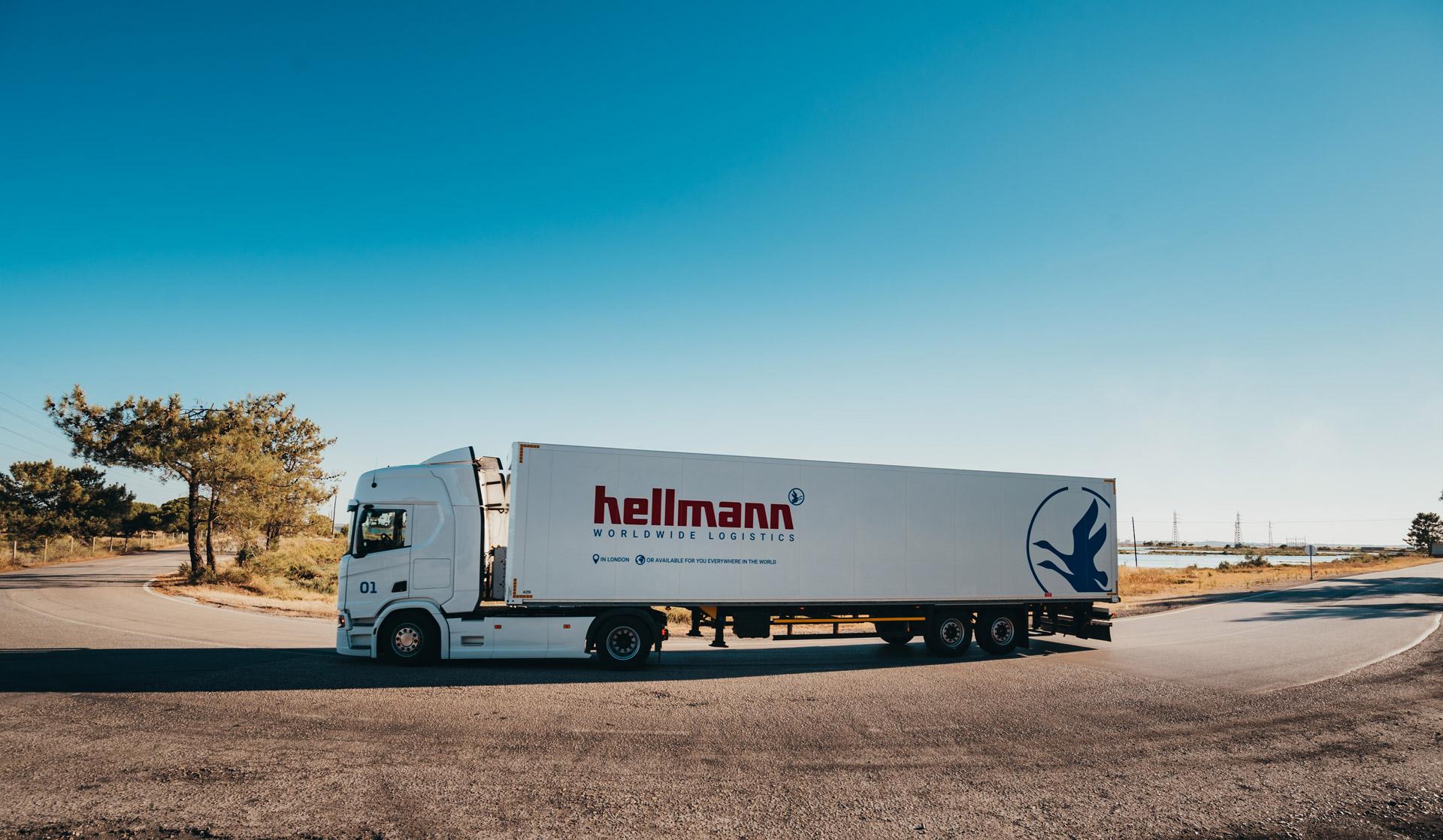 Ein LKW der Firma Hellmann steht auf der Straße.