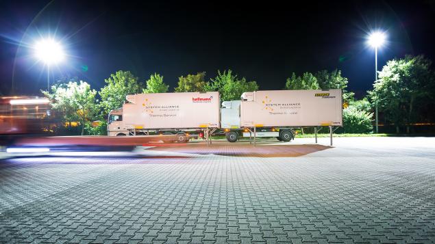 A white System Alliance truck in a loading yard.