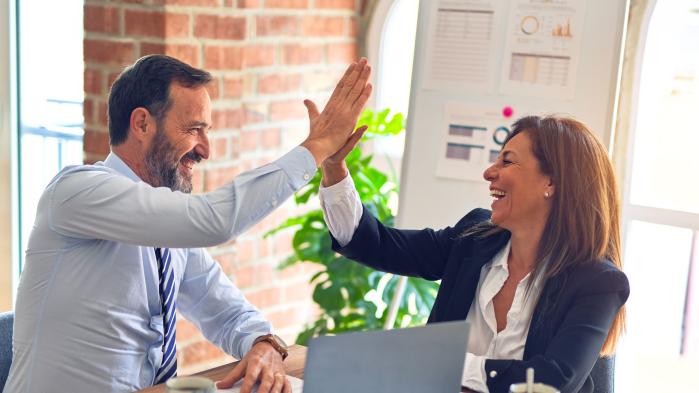 Colleagues high-five each other after successful electronic data integration.