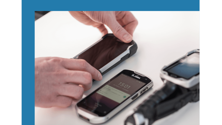 Mobile devices are indispensable in logistics. Three mobile devices are lying on a table.